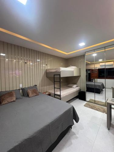 a bedroom with a bed and a loft bed and a couch at Residencial Ibiapaba - APARTAMENTO COMPLETO in Camocim