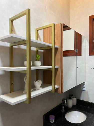 a bathroom with white shelves and a sink at Residencial Ibiapaba - APARTAMENTO COMPLETO in Camocim