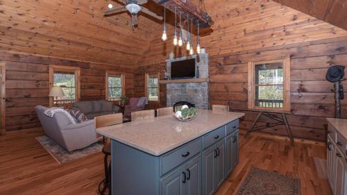 a kitchen and living room in a log cabin at Charming Blue Ridge Cabin Private Pond and Waterfall Deer Haven by AvantStay in Saluda