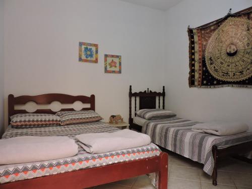 a bedroom with two beds and a mirror on the wall at Casa Do Sol in São Thomé das Letras