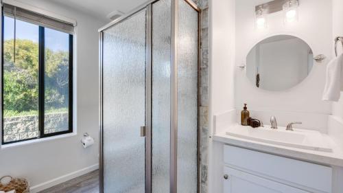 a bathroom with a shower and a sink and a mirror at Strand Way A by AvantStay in Oceano