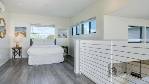 a white bedroom with a bed and windows at Strand Way A by AvantStay in Oceano