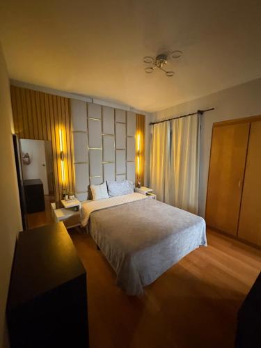 a hotel room with a large bed and a table at Parque plaza residence flat in São Bernardo do Campo
