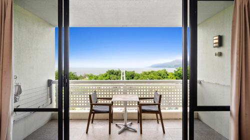 a table and chairs on a balcony with a view at The Studio at Northshore Tower in Cairns North