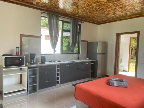 a kitchen with a red bed in a room at Havaii Spot Huahine in HUH