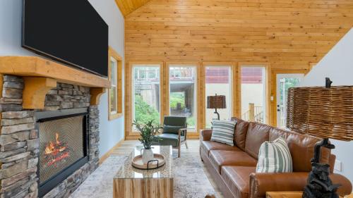 a living room with a couch and a fireplace at Cabin w Hot Tub Game Room Scenic Smoky Mountain Views Perfect by AvantStay in Gatlinburg