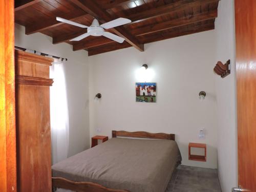 a bedroom with a bed and a ceiling fan at Pucom Pai in San Bernardo