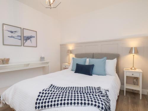 a bedroom with a large white bed with blue pillows at The Nest in Bridlington