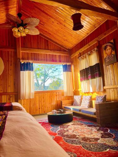 a room with a bed and a couch and a window at Tao Tay House - Ta Van in Sapa