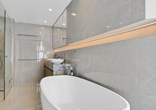 a bathroom with a white toilet and a sink at Bokarina Beachfront Penthouse - Oceanfront Luxury with Exclusive Rooftop Pool & Steam Room in Bokarina