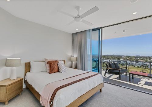 a bedroom with a bed and a large glass window at Bokarina Beachfront Penthouse - Oceanfront Luxury with Exclusive Rooftop Pool & Steam Room in Bokarina