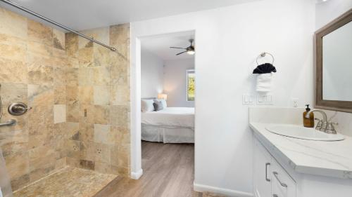 a white bathroom with a shower and a sink at Strand Way B by AvantStay in Oceano