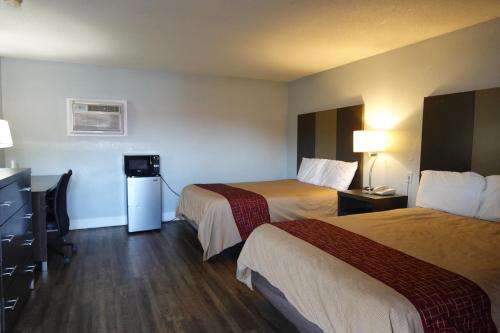 a hotel room with two beds and a desk at Cascades Motel - Chattanooga in Chattanooga