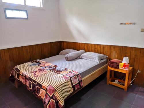 a bedroom with a bed and a nightstand next to it at De PO'ONG in Ruteng