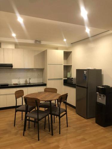 a kitchen with a table and chairs and a refrigerator at GQ Apartment in Aklan