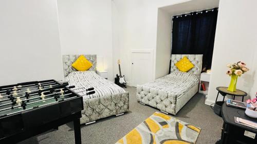 a living room with two beds and a foos ball at Spacious 3 Bedroom Entire Apartment Self Check in & Free Parking in Cowdenbeath