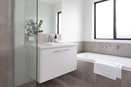 a bathroom with a white sink and a bath tub at King Bed, 3 Beds, 2 bath, Sleeps 6 in Sale