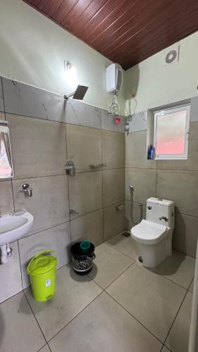 a bathroom with a toilet and a sink at Riverfolk Stays in Thodupuzha