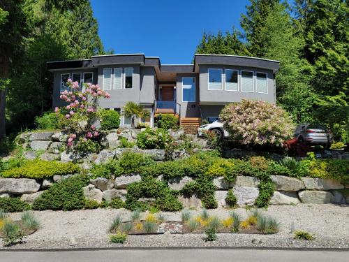 a house with a garden in front of it at Modern Coastal 2BR Retreat with Private Hot Tub in Vancouver BC in West Vancouver
