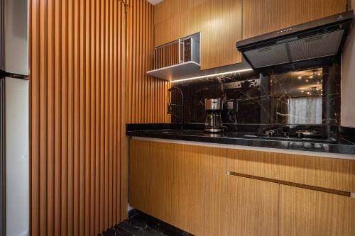 a kitchen with wooden cabinets and a black counter top at Departamento cerca de Estadio GNP y Aeropuerto in Mexico City