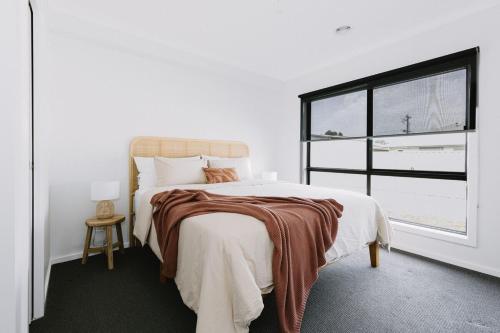 a white bedroom with a bed and a window at King Bed, 3 Beds, 2 bath, Sleeps 6 in Sale