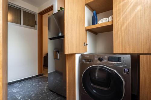 a laundry room with a washer and a refrigerator at Departamento cerca de Estadio GNP y Aeropuerto in Mexico City