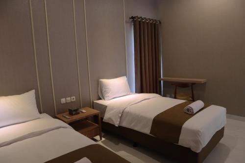 a hotel room with two beds and a window at Wakayapa Syariah Residence in Dahung