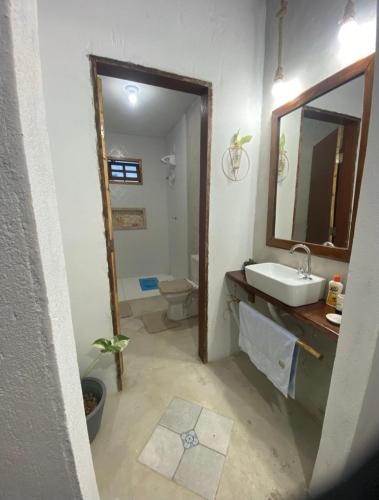 a bathroom with a sink and a toilet and a mirror at Casa de pedra in Prado