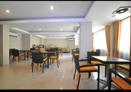 a dining room with tables and chairs in a restaurant at Hotel GRANDSARASWATI in Stasiun Poncol