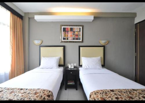 two beds in a hotel room with two beds sidx sidx sidx at Hotel GRANDSARASWATI in Stasiun Poncol