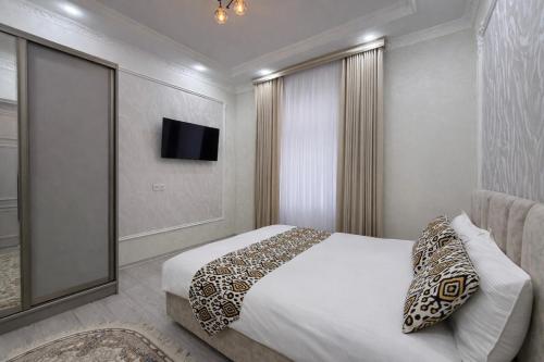 a hotel room with a bed and a television at Mumtoz Hotel in Samarkand