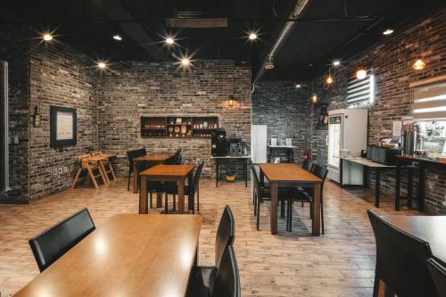 un ristorante con tavoli e sedie in legno e pareti in mattoni di Hotel Iam a Suncheon