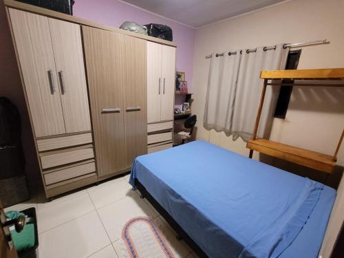 a bedroom with a blue bed and wooden cabinets at Encanto da Rosa in Cavalcante