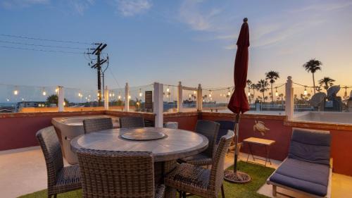 a patio with a table and chairs on a balcony at Shoreline Villa by AvantStay Steps to the Beach Bay Pier in Newport Beach