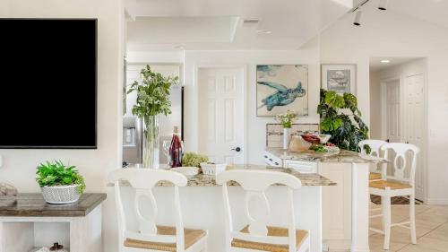 a white dining room with a white table and chairs at Shoreline Villa by AvantStay Steps to the Beach Bay Pier in Newport Beach