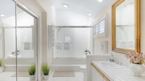 a white bathroom with a shower and a sink at Shoreline Villa by AvantStay Steps to the Beach Bay Pier in Newport Beach