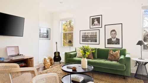 a living room with a green couch and a tv at Hart Suite 9 by AvantStay Gorgeous Town House w Modern Amenities in Nashville in Nashville