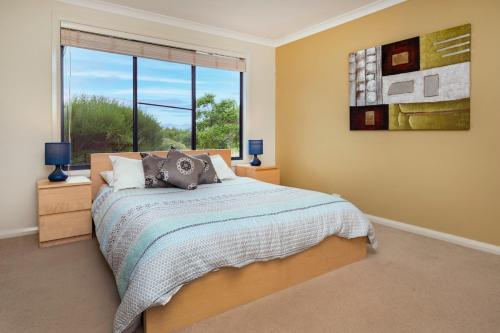 a bedroom with a bed and a large window at Sea Forth on Otter in Quindalup