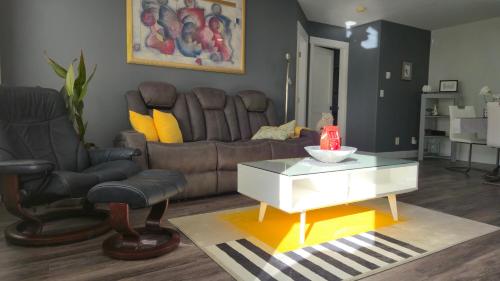 a living room with a leather couch and a coffee table at Modern Coastal 2BR Retreat with Private Hot Tub in Vancouver BC in West Vancouver
