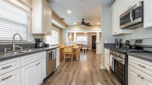 a kitchen with white cabinets and a wooden floor at Sea Sight by AvantStay Walk to Newport Beach in Newport Beach