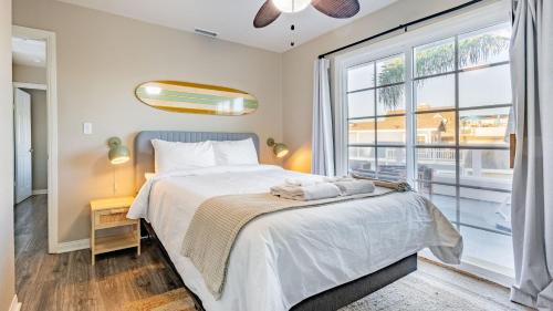a bedroom with a bed and a large window at Sea Sight by AvantStay Walk to Newport Beach in Newport Beach