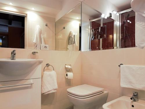 a white bathroom with a sink and a toilet at Aretusa Apartments in Siracusa