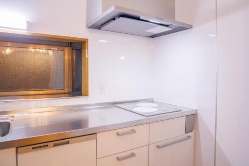 a kitchen with a sink and a window at North Nagano Inn in Iiyama