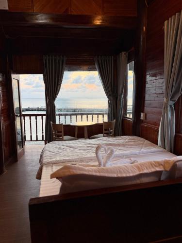 a bedroom with a bed with a view of the beach at Bungalow Hải Yến in Ly Son