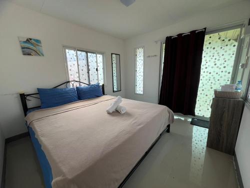 a bedroom with a large bed with blue pillows at Rimkuan Lakeview in Ban Kham Kom
