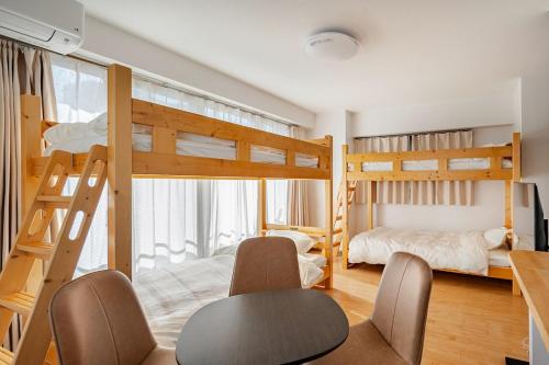 a room with two bunk beds and a table and chairs at ライズ 2人部屋 か4人部屋 in Kasugai