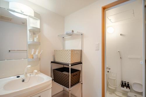 a bathroom with a white sink and a shower at ライズ 2人部屋 か4人部屋 in Kasugai