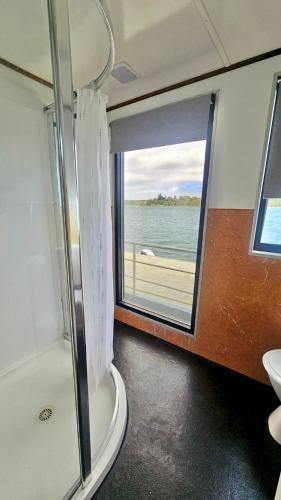 a bathroom with a shower and a view of the ocean at Waterscape Floating Apartment in Augusta