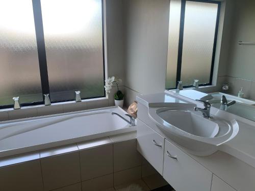 a bathroom with a tub and a sink and mirrors at Private Retreat in Cambridge