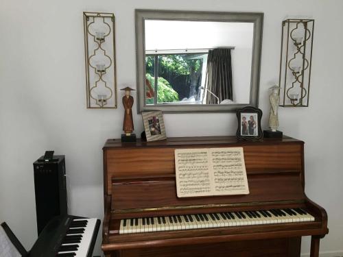 a piano sitting in a room with a mirror at Private Retreat in Cambridge